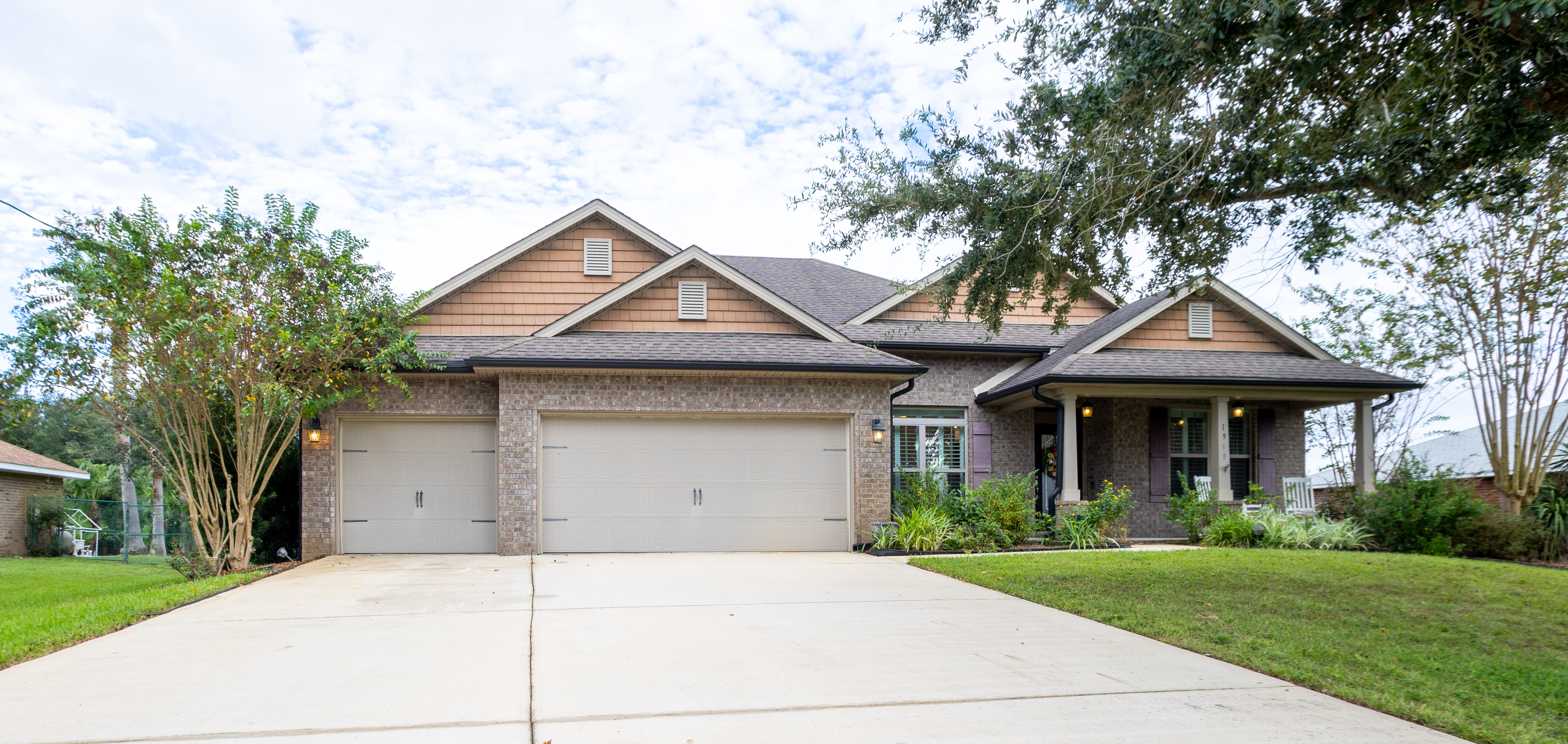 A single-story brick home with a landscaped front yard